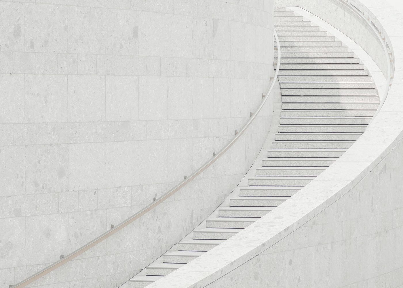 Escada curva revestida em mármore branco